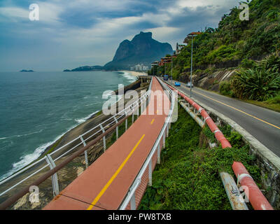 Highway by the sea. Wonderful road and bike path. Bicycle and road track and next to the blue sea in the city of Rio de Janeiro. Tim Maia bike path.