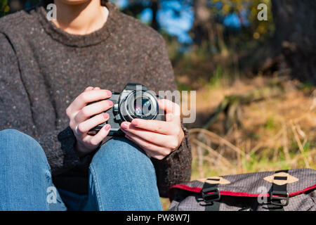 Vintage film camera in female hands. Close up shot of a woman holding film camera outdoors