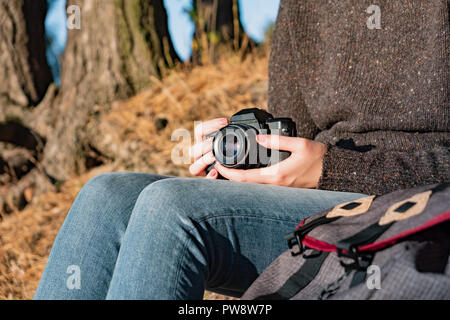 Vintage film camera in female hands. Close up shot of a woman holding film camera outdoors Stock Photo