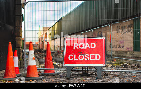 A road closed sign and bollards stop cars from using a road in Sheffield, UK Stock Photo