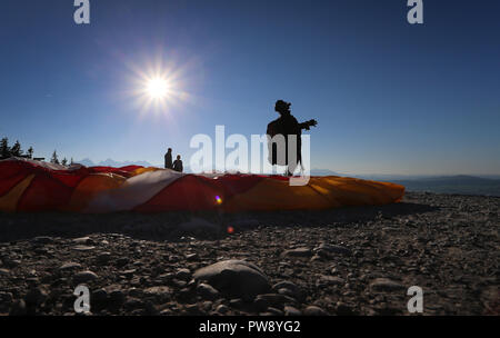 Buching, Bavaria. 13th Oct, 2018. 13 October 2018, Germany, Buching: A paraglider is waiting for the right wind to take off on the Buchenberg Alm in the sunshine at an altitude of around 1100 metres. Credit: Karl-Josef Hildenbrand/dpa/Alamy Live News Stock Photo