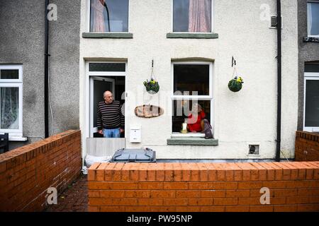 Saturday 13th October 2018. Tonna, South Wales, UK.  Flooding effected the villages of Aberdulais and Tonna in the Neath Valley after Storm Callum brought heavy rain and wind to the area causing the River Neath to reach bursting point.  A couple look out from their property at Canal Side, Tonna, Neath. Robert Melen/Alamy Live News. Stock Photo