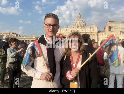 Vatican City, Vatican. 14th Oct, 2018. Kerstin Schäfer and her husband Sebastian from the Westerwald are waiting in St. Peter's Square for the beginning of the ceremony for the canonization of the German nun Katharina Kasper (to be seen on the little flag), who has come to St. Peter's Square in Rome. Credit: Annette Reuther/dpa/Alamy Live News Stock Photo