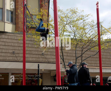 Two Rivers, Wisconsin USA, 13th Oct, 2018.  Young girl does a flip on a controlled bungee rebounder trampoline during street fair at Two Rivers Annual Autumn Applefest. Credit: Jerome Wilson/Alamy Live News Stock Photo