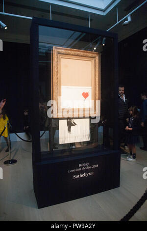 London, UK. 14th October 2018. Banksy's  'Love is in the bin' is on view to the public at Sothebys in New Bond Street London. The artwork  which was formerly known as 'The Girl with a Ballon' was shredded moments after the winning bid and the hammer fell at auction to a foreign buyer on October 5th Credit: amer ghazzal/Alamy Live News Stock Photo