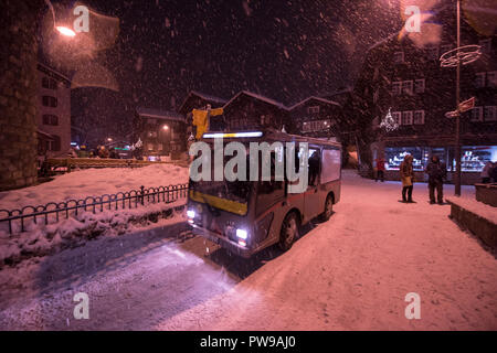 Electric taxi bus on snowy streets in the car-free Alpine mountain village at cold winter night Stock Photo