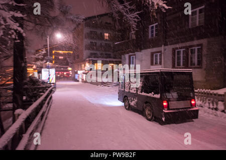 Electric taxi bus on snowy streets in the car-free Alpine mountain village at cold winter night Stock Photo