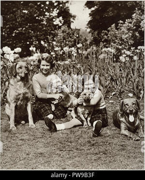 Princess Elizabeth the future Queen Elizebeth II and her sister Princess Margaret in posing with their pet dogs in the grounds of Windsor castle photographed in 1937 Stock Photo