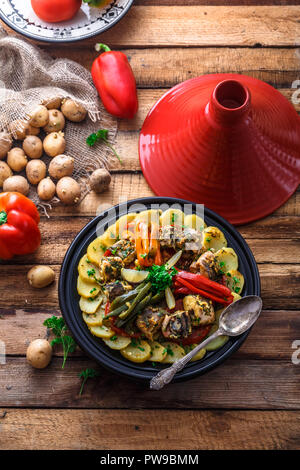 Fish tajine mqualli with potato and bell peppers, top view. Stock Photo