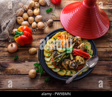 Fish tajine mqualli with potato and bell peppers, top view. Stock Photo