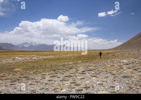 Trekker in Tajik Wakhan with Afghan Great Pamir in background on trek from Keng Shiber to Kara Jilga, Pamir Mountains, Gorno-Badakhshan, Tajikistan. Stock Photo