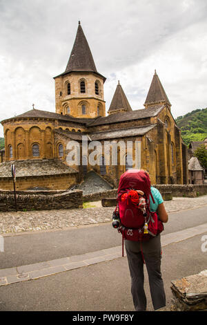 Pilgrim walking the Camino through the town of Conques in France to the Spanish town of Santiago de Compostela. Stock Photo