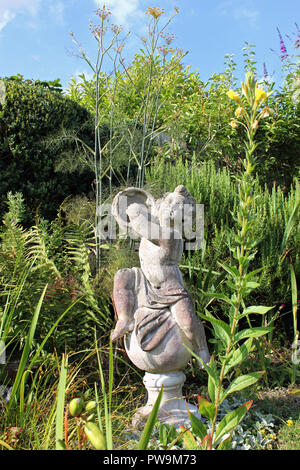 Garden stone statue of boy playing tambourine Stock Photo