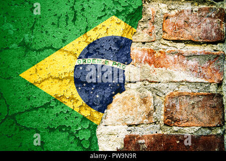 Brazil national flag painted on cracked divided peeling pain brick wall cement facade. Concept for Brazilian Portuguese language, culture and politica Stock Photo