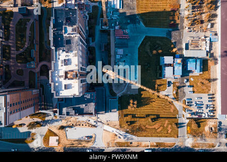 Aerial  top city view with crossroads, roads, houses, buildings, parks and parking lots in sunny autumn day. Copter drone helicopter shot. Stock Photo