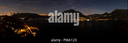 Panorama overlooking Lake Como and surrounding mountains in northern Italy at night Stock Photo