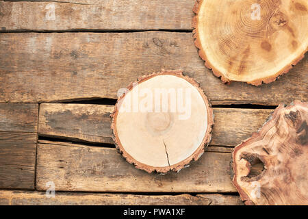 Wooden slices on rustic background. Round wooden pieces and copy space. Wooden discs for decoupage. Rustic still life. Stock Photo