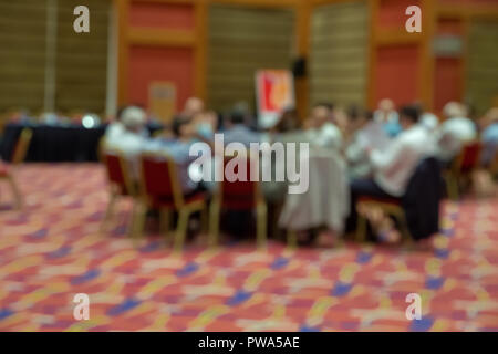 Blurred photo of audience group attending in conference meeting room. Group of business people attending press conference or presentation. Stock Photo