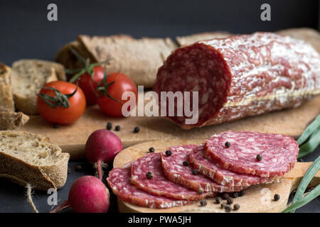 Sausage pieces, potatoes and bread isolated on dark background Stock Photo