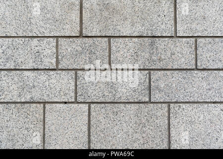 Grey granite brick wall background texture with different sized rectangular blocks in a full frame background Stock Photo