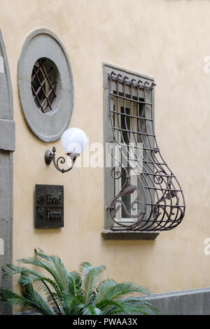 Unusual decorative wrought iron window security grill on house in old town of Pistoia, Tuscany, Italy, Europe, Stock Photo