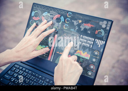 Businesswoman hand using advance technology computer touch screen business information data chart outdoor for decision support system Stock Photo