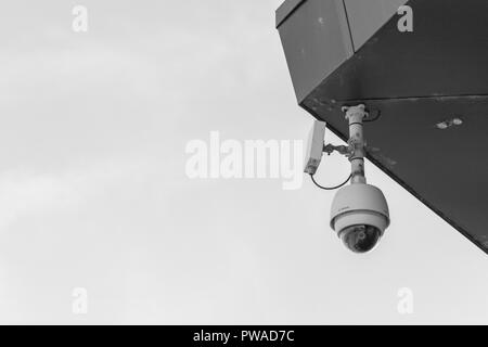 CCTV surveillance camera 'Watching Over You'. Crime prevention metaphor, surveillance state, security system, face recognition concept. Stock Photo
