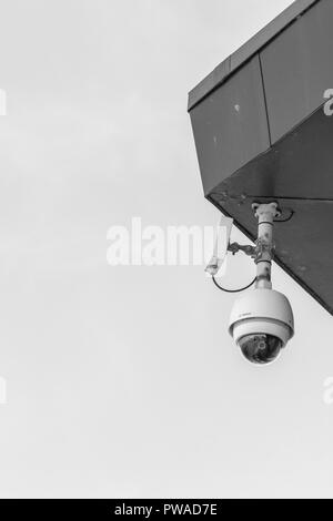 CCTV surveillance camera 'Watching Over You'. Crime prevention metaphor, surveillance state, security system, face recognition concept. Stock Photo