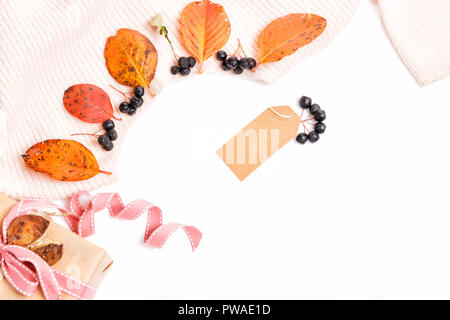 Woomen gentle beige pink sweater, dry autumn leaves and aronia berries on a white background, Autumn, fall concept., autumn shopping and discounts concept . Flat lay, top view, copy space Stock Photo
