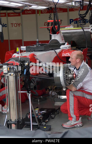F1 mechanics at work on a Toyota F1 race car in the pit lane workshop ...