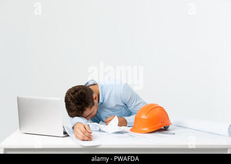 young attractive engineer man feeling tired at work place Stock Photo