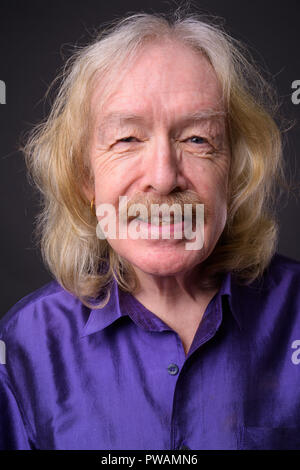 Senior man with mustache against gray background Stock Photo