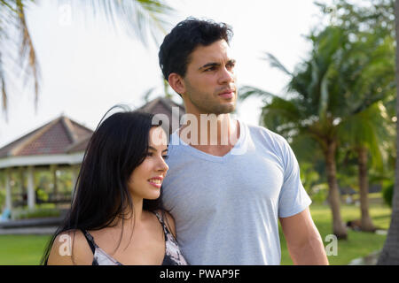 Young Hispanic couple relaxing in the park together Stock Photo