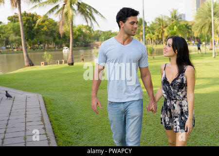 Young Hispanic couple relaxing in the park together Stock Photo