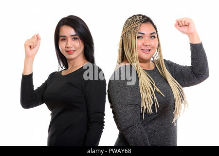 Young happy Asian transgender woman and fat Asian woman smiling  Stock Photo