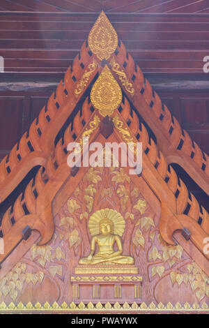a wood carving depictiong image of people on the wall of temple in Thailand Stock Photo