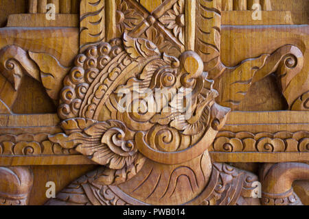 a wood carving depictiong image of a giant on the door of temple in Thailand Stock Photo