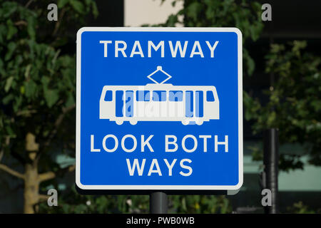 A sign reads 'Tramway Look Both Ways' in St Peter's square in Manchester, referring to the city's Metrolink system. Stock Photo