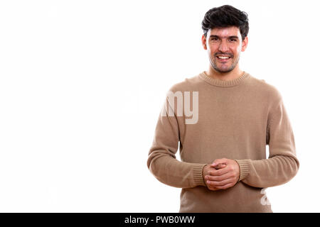 Studio shot of young happy Persian man smiling  Stock Photo