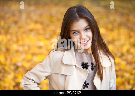 Beautiful teen girl 12-14 year old wearing trendy autumn clothes posing at  countryside. Looking at camera. Stock Photo