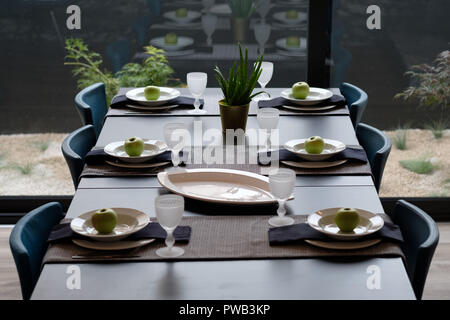 Overhead view of a long dining table set with six plates Stock Photo