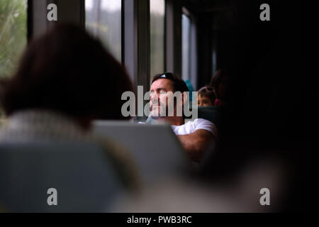Man asleep on public transport seat Stock Photo