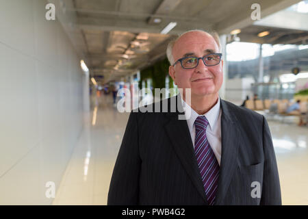 Overweight senior businessman lounging around the airport of Ban Stock Photo