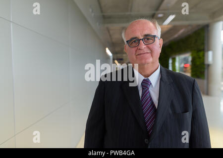 Overweight senior businessman lounging around the airport of Ban Stock Photo