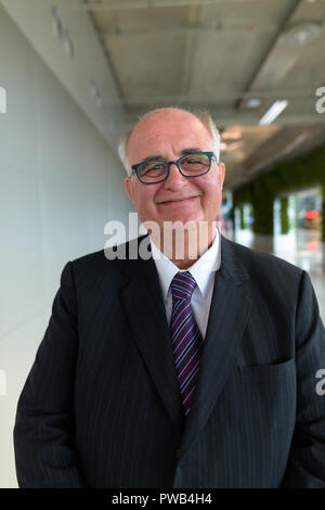 Overweight senior businessman lounging around the airport of Ban Stock Photo