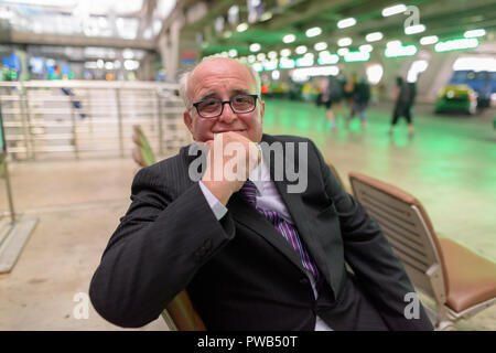 Overweight senior businessman lounging around the airport of Ban Stock Photo