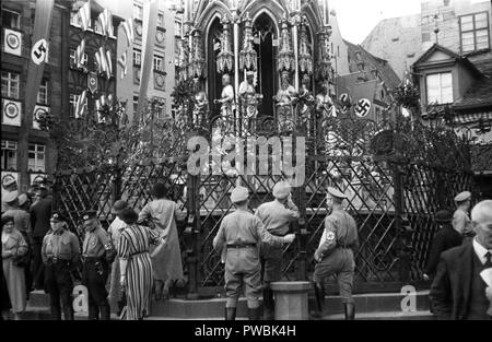 Germans  around the Schoene Brunnen or Beautiful Fountain in Hauptmarkt Square. Nuremberg, Bavaria, Germany for the Nazi Germany NSDAP Nuremberg Rally 1936 Parade at the rally ground 10th September 1936 Stock Photo