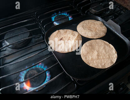 Nutritious handmade corn tortilla cooked on a metal griddle on a gas stove  in a Guatemalan home Stock Photo - Alamy