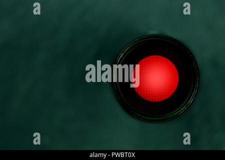 A photo of a vibrant red button, shot from the top, a kill switch on a dark panel with a place for text Stock Photo