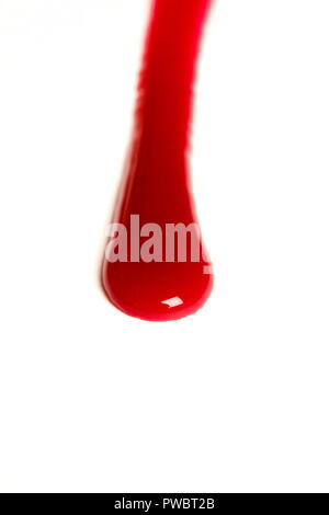 drop of blood dripping on a white surface Stock Photo